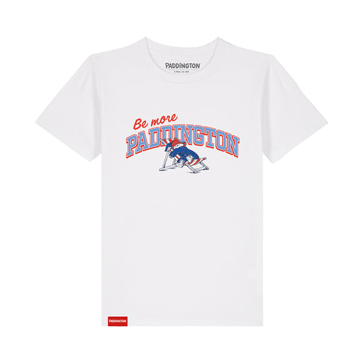 A white short-sleeve crewneck t-shirt featuring a 'Be more PADDINGTON' graphic on the chest with a blue and red Paddington bear on a deckchair illustration. The brand name 'PADDINGTON' is printed inside the collar, and a small red tag is visible near the bottom left hem.