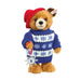 Teddy bear wearing a blue sweater with white snowflake patterns and a red hat on a white background