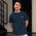 An Asian man wearing a navy blue Paddington t short with logo in front of a door and set of stairs 