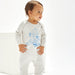 Baby wearing a white onesie with a blue bear design on a white background