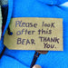 Textile luggae tag on a blue fabric background with 'Please look after this BEAR THANK YOU.' text.