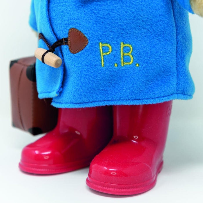 Blue shirt with 'P.B.' and a brown tool graphic, red rain boots, and a suitcase on a white background