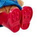 Close-up of a teddy bear wearing red boots with 'P.B.' branding on a white background