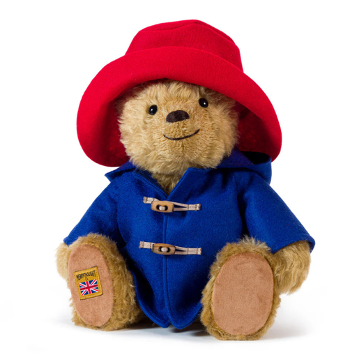 A Merrythought collectors Paddington teddy Bear plush toy wearing a red hat and blue duffle coat with toggle closures, photographed on a clean white background.