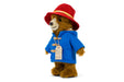 Stuffed toy Paddington teddy bear in a red hat and blue coat with a tag on a white background