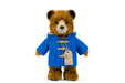 Stuffed teddy bear wearing a blue coat with a tag on a white background