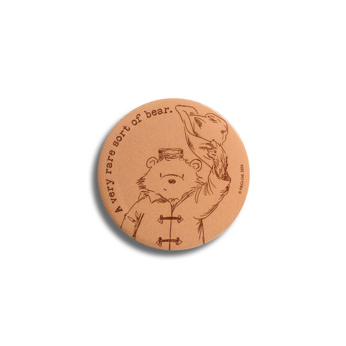 Round, orange Paddington sketch badge on a white background