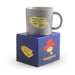 Gray mug with yellow label on a blue Paddington Bear box
