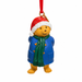 Christmas-themed bear ornament with a red hat, blue coat, and green scarf on a white background.