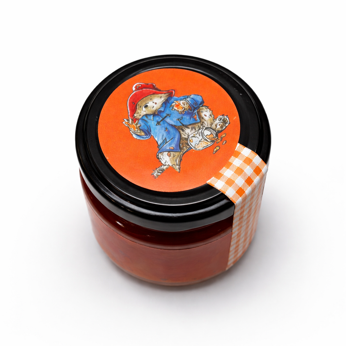 Jar with a decorative lid featuring a character and checkered ribbon on a white background