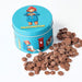 Blue tin with Paddington Bear design, filled with chocolate buttons on a white background