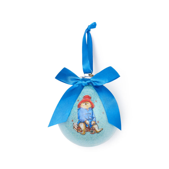 Decorative ornament with a blue ribbon and a Paddington bear character design on a white background