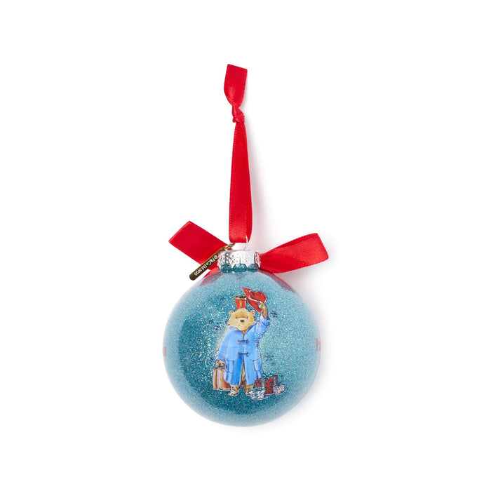 Blue decorative Christmas ball ornament with a Paddington bear design and red ribbon on a white background