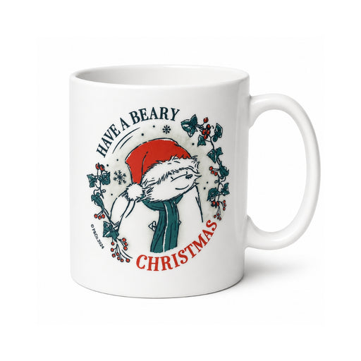 A white ceramic mug featuring a festive illustration of a Paddington bear Christmas character wearing a red Santa hat and green scarf, surrounded by holly leaves and the text 'HAVE A BEARY CHRISTMAS'.