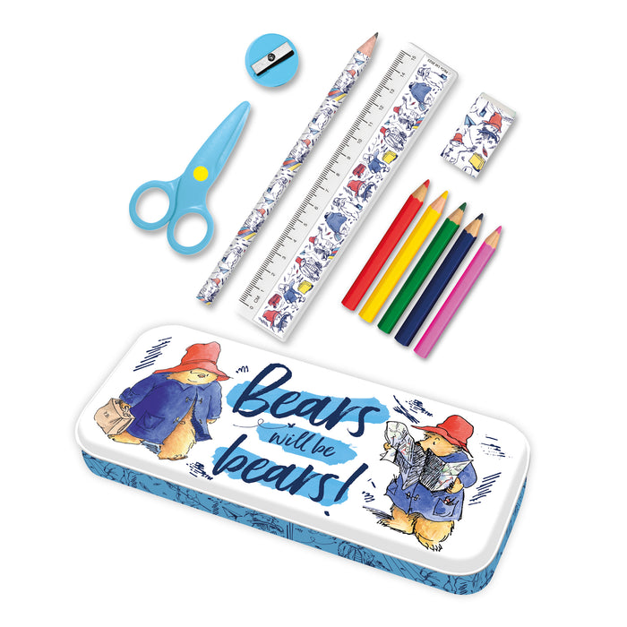 A stationery tin set featuring illustrations of Paddington bear in various poses with pencils, paper clips, scissors, and a ruler arranged on top.