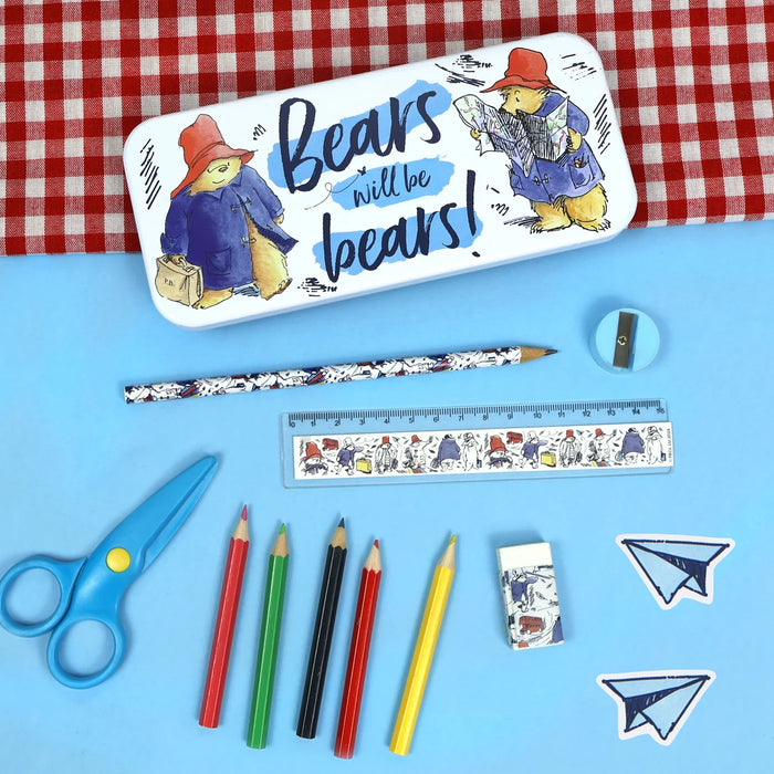 A flat-lay of a Bears will be Bears pencil case set on a light blue background with a red-and-white gingham cloth at the top. The set includes a white pencil case with colorful Bear illustrations and the text 'Bears will be bears!', a pencil, a small eraser, a ruler, a pair of blue scissors, several colored pencils.