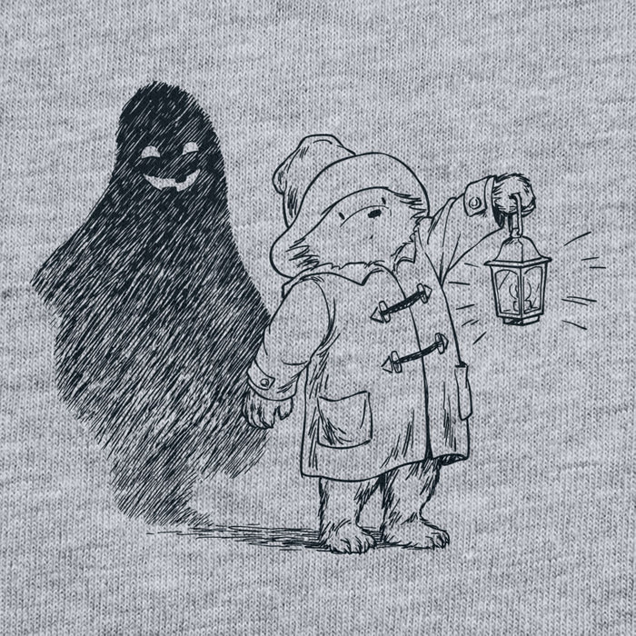 Illustration of Paddington bear holding a lantern with a shadowy figure behind it on a textured gray background.