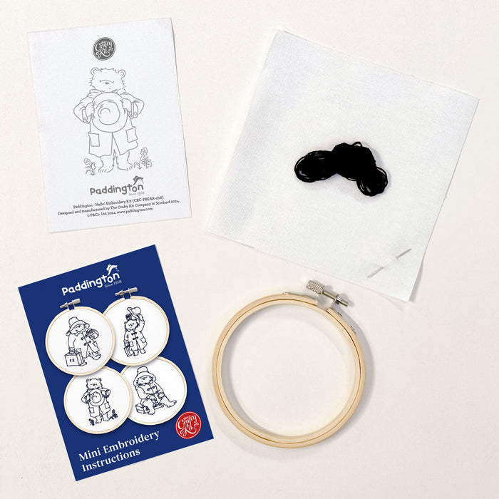 A mini embroidery kit depicting Paddington Bear waving hello, mounted in a hoop.