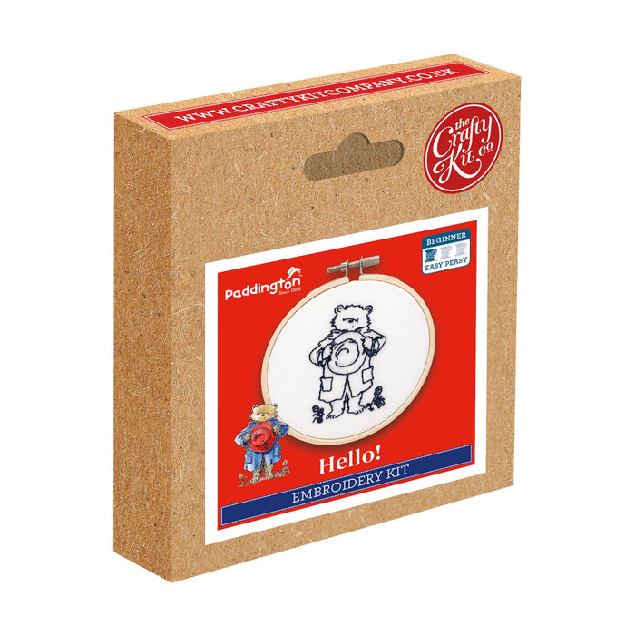 A box with a mini embroidery kit depicting Paddington Bear waving hello, mounted in a hoop.