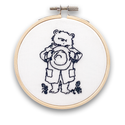 A mini embroidery kit depicting Paddington Bear waving hello, mounted in a hoop.
