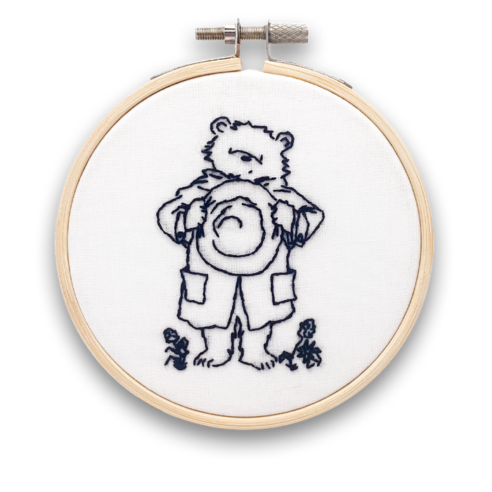A mini embroidery kit depicting Paddington Bear waving hello, mounted in a hoop.