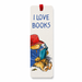 A vertical white bookmark with a red hanging loop at the top, printed with the phrase 'I LOVE BOOKS' in blue lettering and an illustration of Paddington bear reading a blue book. The bear wears a red hat and blue coat.