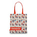 A canvas tote bag featuring a repeating Paddington Bear pattern on a cream background, with bright red handles and a red band at the bottom displaying the word 'PADDINGTON' in white text.