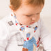 A young baby or infant wearing A white baby bib bandana with repeating paddington artwork all over