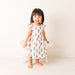 Child wearing a dress with a colorful pattern on a white background