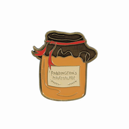 A pin badge featuring a jar of Paddington Marmalade with a label and a red ribbon on top.
