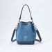 A blue denim bucket bag with navy blue leather trim, silver-tone hardware, and a white embroidered 'PB' monogram on the front, set against a plain white background.