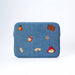 A blue denim laptop case featuring Paddington bear embroidery and props including an orange, suitcase, marmalade jar, pawprint, luggage tag, marmalade sandwich and Paddington's face.