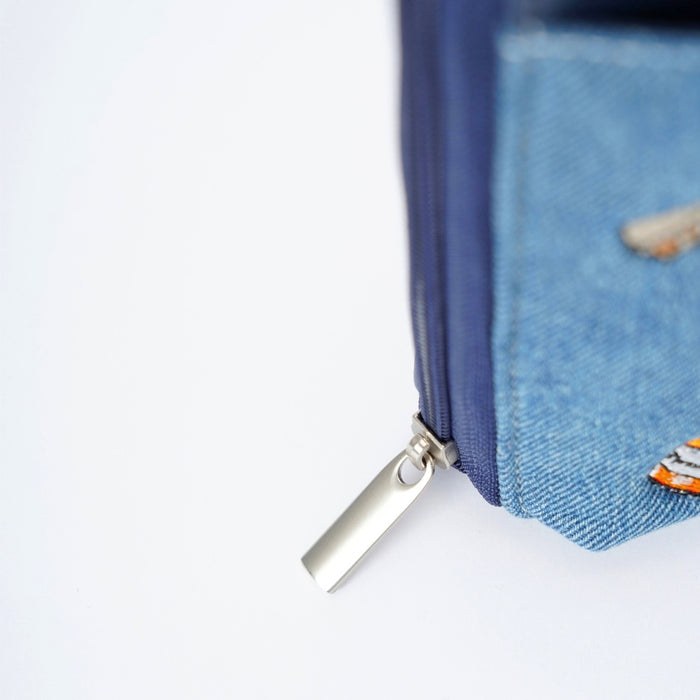 Close-up of a blue denim zippered phone bag with a silver metal zip on a white background.