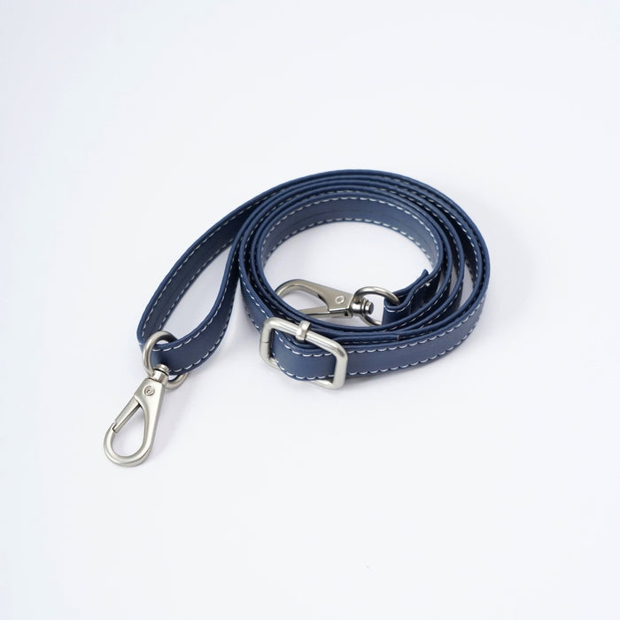 A navy blue faux leather shoulder strap with white contrast stitching, featuring silver metal hardware including a swivel snap hook and a rectangular buckle, displayed on a clean white background.