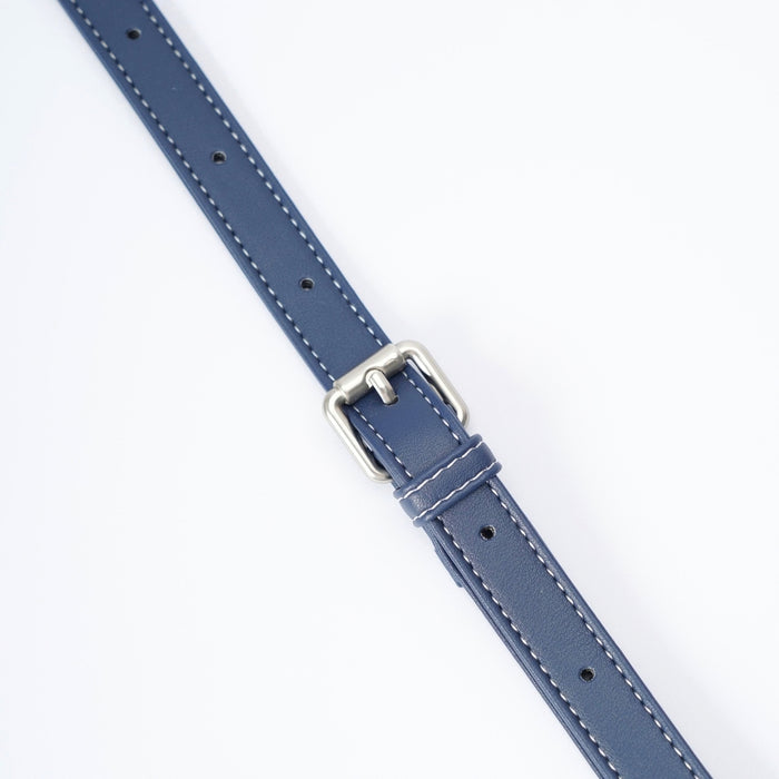 A close-up of a blue leather handbag strap with white stitching and a silver buckle, shown diagonally on a plain white background.