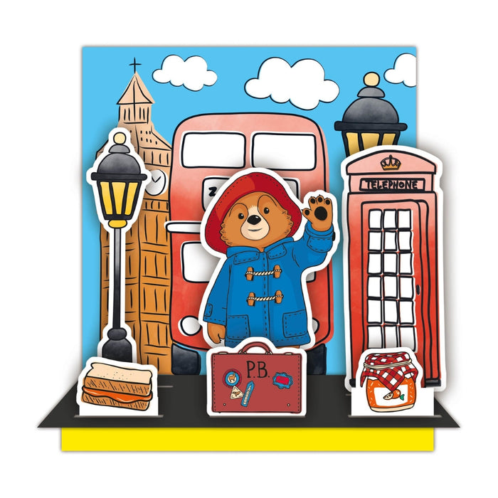 Cartoon bear in a blue coat with British icons like a red bus and phone box on a blue background.