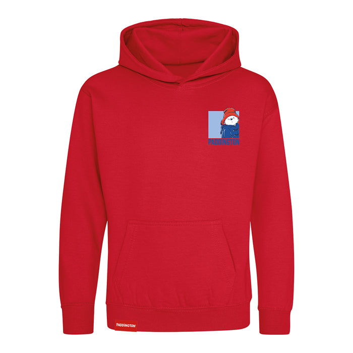 A red pullover hoodie with a small graphic on the left chest depicting a cartoon Paddington bear wearing a red hat and blue outfit, with the text 'PADDINGTON' below. The hoodie has a front kangaroo pocket and ribbed cuffs and hem, shown on a plain white background.