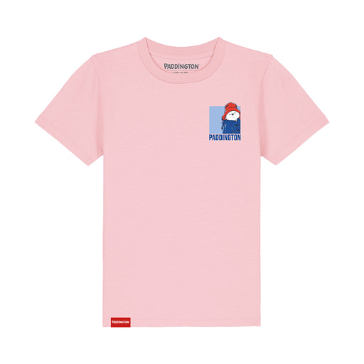 A light pink short-sleeve t-shirt featuring a small cartoon graphic of Paddington Bear on the left chest and a red Paddington brand tag near the bottom hem, displayed on a clean white background.