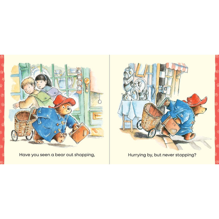 A two-panel illustrated book spread showing Paddington Bear shopping in a shop, with children in the first panel and Paddington continuing his shopping trip in the second panel. The pages have a cream background with red side borders and printed text at the bottom.