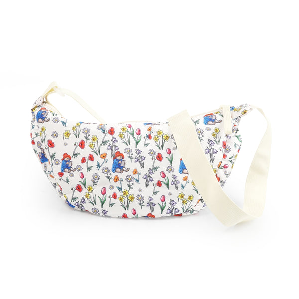 Floral-patterned and Paddington bag with a strap on a white background