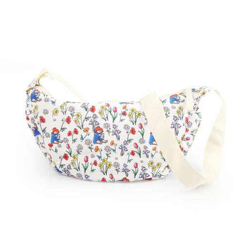 Floral-patterned and Paddington bag with a strap on a white background