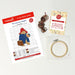 Cross stitch kit with pattern, thread, and hoop on a light background