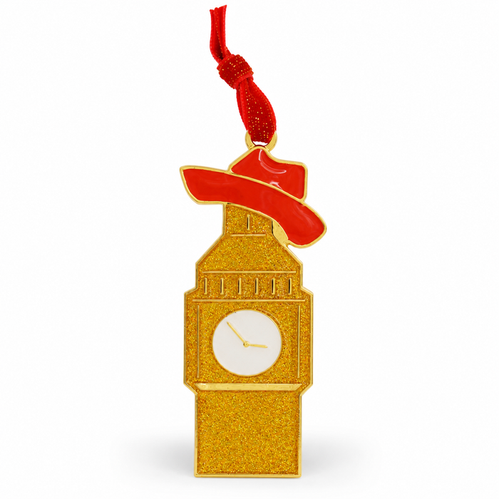 A gold glitter Big Ben clock-shaped ornament with a red hat and a red hanging ribbon, shown on a plain white background. 