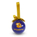 A round blue Paddington The Musical hanging Christmas ornament with a gold ribbon loop and bow, featuring the Paddington The Musical pawprint logo and title on a white background.