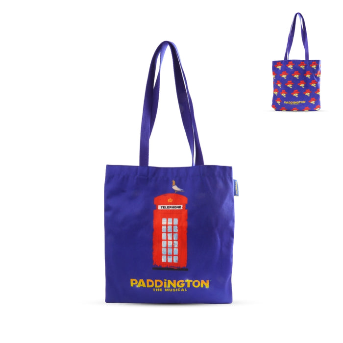 Blue tote bag with red telephone box and 'Paddington the Musical' text, smaller bag with patterned design in the corner.
