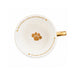 White ceramic teacup with a gold paw print in the center and gold decorative text and paw prints around the rim, featuring a gold handle on a white background.