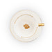 A white ceramic teacup and saucer set with gold trim, featuring a gold paw print in the center and gold text around the rim, shown from a top-down view on a white background.