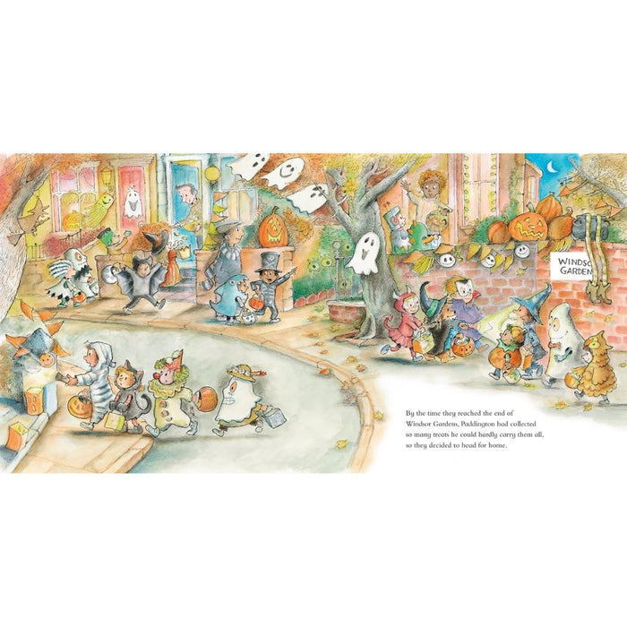 A wide, colorful illustrated scene showing a whimsical Halloween street with ghosts, pumpkins, cats, Paddington bear and people in costume. Small text appears along the bottom right, and the artwork is presented on a white page-like background.