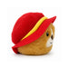 A round Paddington bear plush toy with golden-brown fur wearing a bright red hat with a yellow band, photographed on a clean white background.