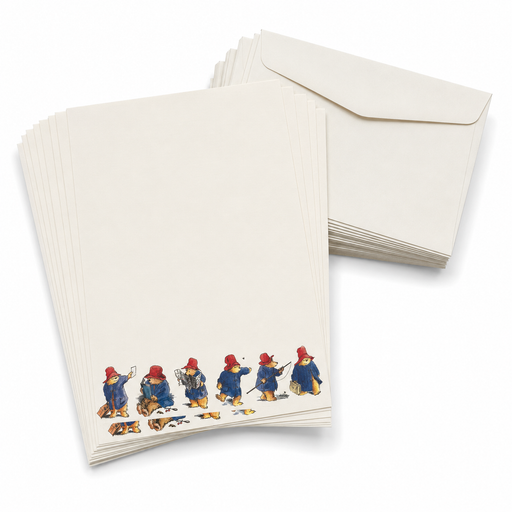 A stack of cream-colored stationery cards featuring a row of Paddington Bear illustrations along the bottom edge, shown with matching cream envelopes on a white background.